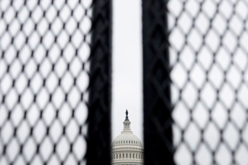 FILE PHOTO: Security fences, erected following the January 6th attack, are seen surrounding the U.S. Capitol in Washington, U.S. March 24, 2021. REUTERS/Carlos Barria