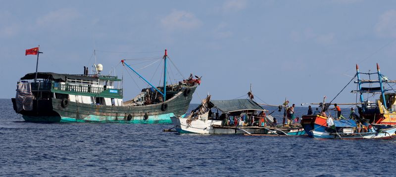 FILE PHOTO: A Chinese fishing vessel is anchored next to Filipino fishing boats at the disputed Scarborough Shoal April 6, 2017. Picture taken April 6, 2017 REUTERS/Erik De Castro/File Photo