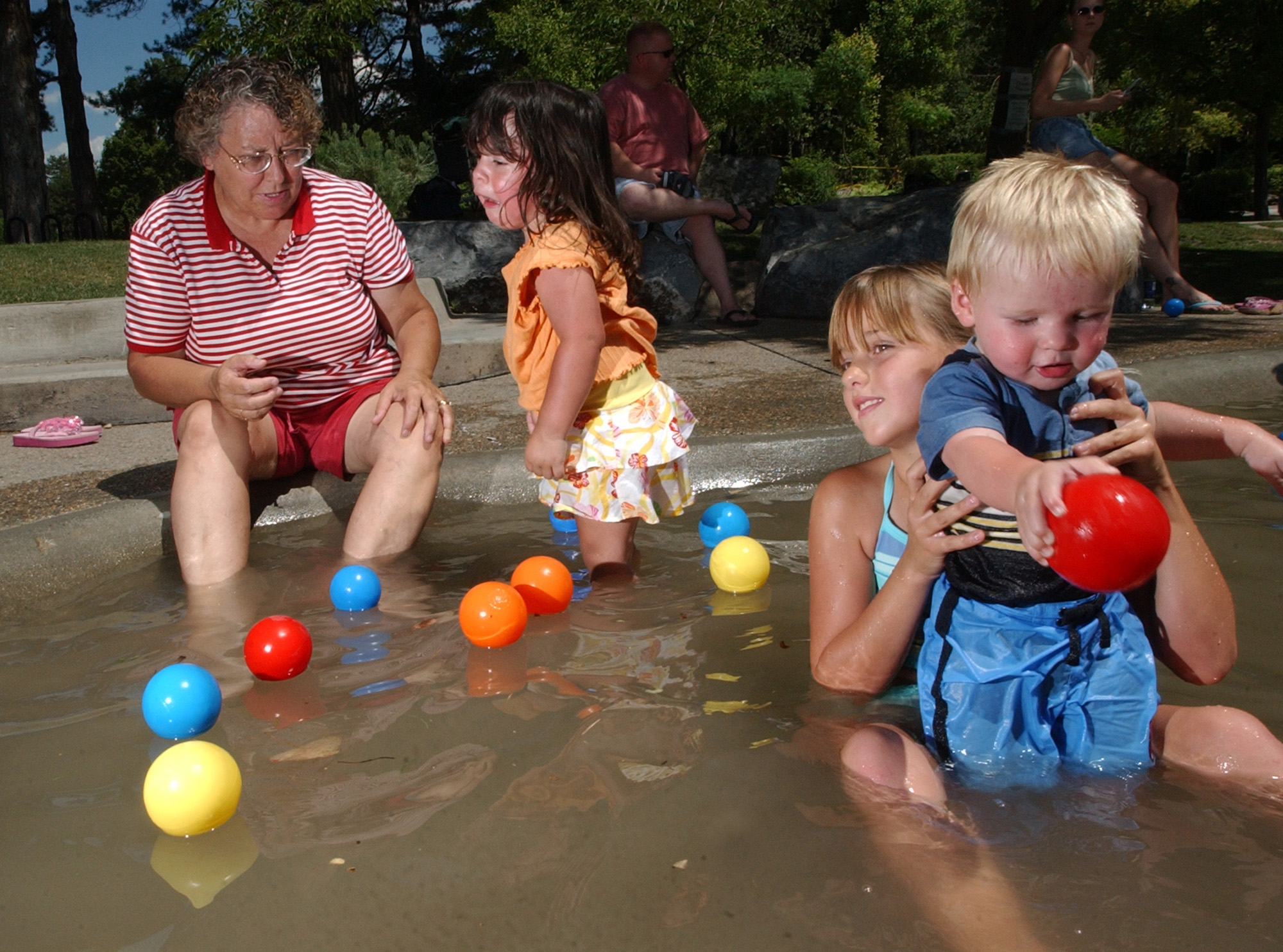 Taylorsville resident Janet Worthen, left, entertains her grandchildren Madison Ramirez, 2, Jaycie Le Baron, 8, and Carson Le Baron, 10 months, at the Seven Canyons fountain in Liberty Park on July 13, 2005. Salt Lake City officials announced on Friday, May, 26, 2017, that the fountain will not be open this summer due to public health and safety concerns. That decision was later made permanent