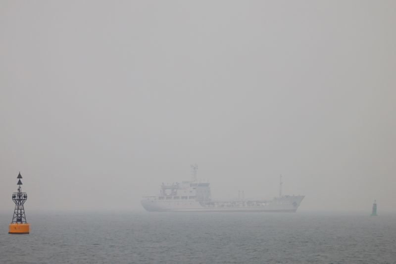 A People's Liberation Army (PLA) Navy vessel is seen in fog off the coast of Qingdao, Shandong province, China, following an oil spill in the Yellow Sea caused by a collision between tanker A Symphony and bulk vessel Sea Justice off Qingdao port, April 29, 2021. REUTERS/Carlos Garcia Rawlins