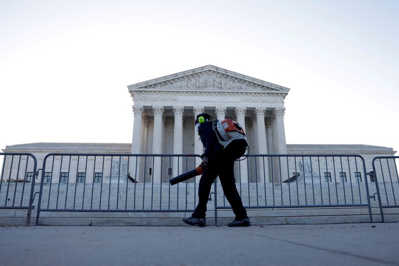 FILE PHOTO: A worker clears front steps as morning rises over the U.S. Supreme Court building, still closed to the public during the COVID-19 pandemic, in Washington, U.S. April 26, 2021.  REUTERS/Jonathan Ernst/File Photo