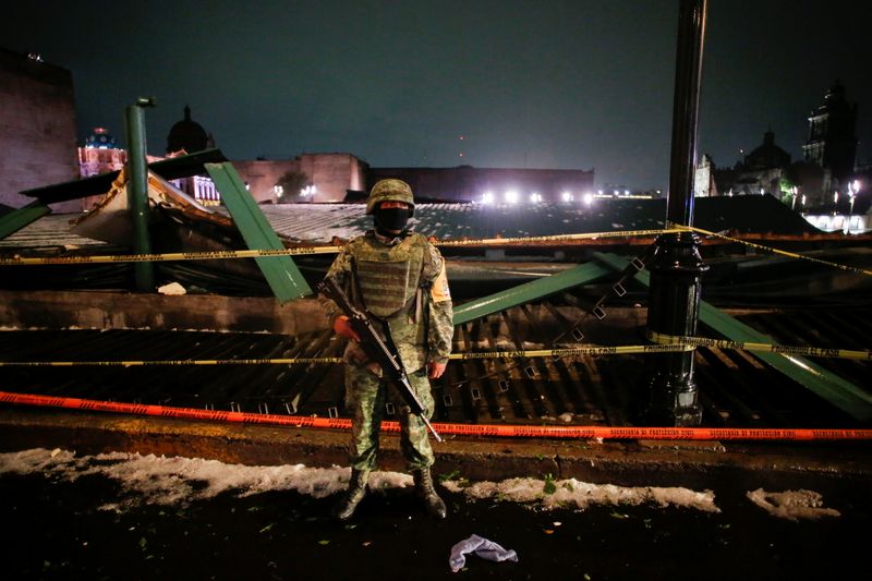 A soldier keeps watch at a scene where the roof protecting the "Casa de las Aguilas", part of the ruins of the Templo Mayor archaeological site, collapsed after heavy rain and hail, in downtown Mexico City, Mexico April 28, 2021. REUTERS/Gustavo Graf