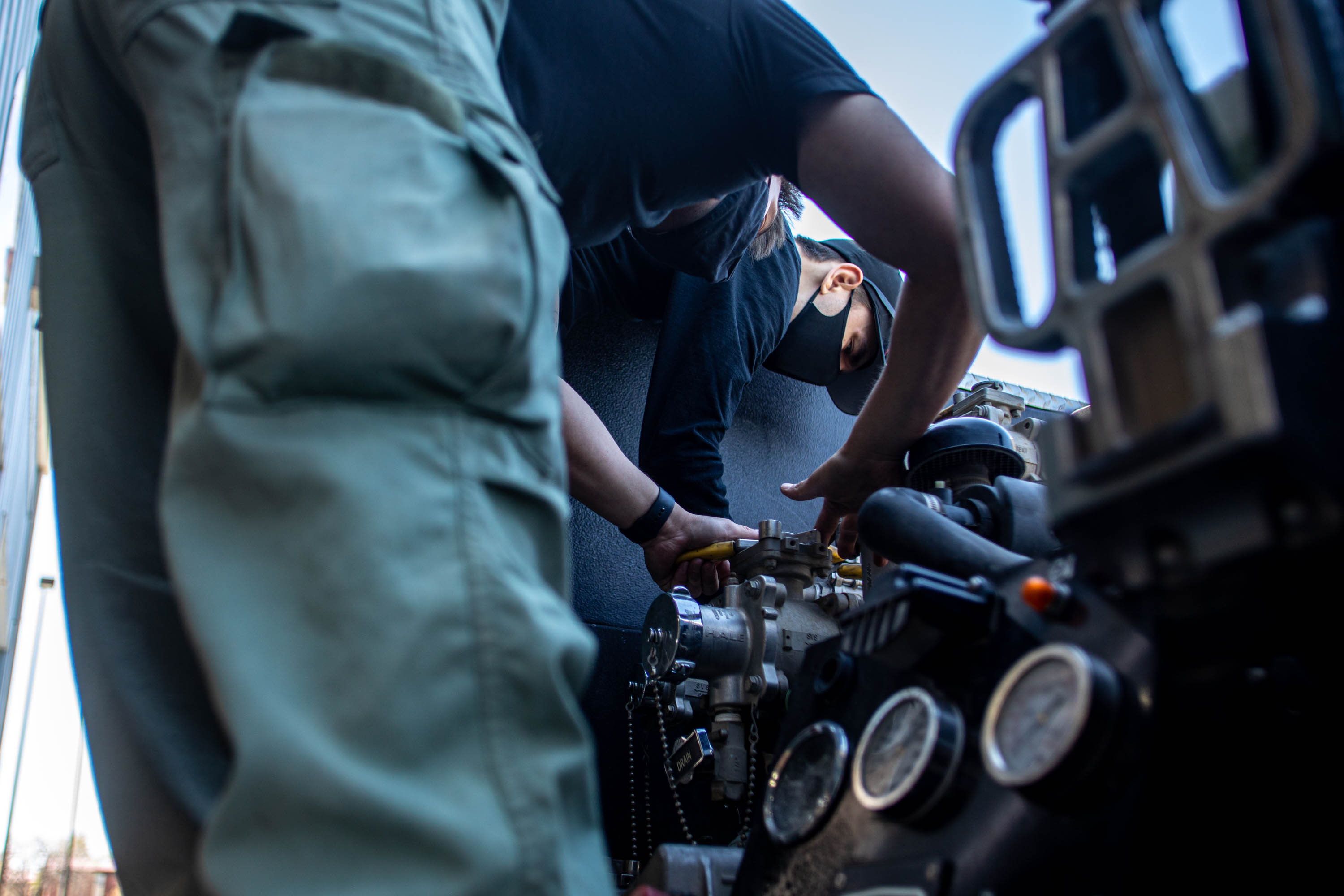 Victor Sanchez, front, and Connor Robinson, back, check a vehicle in Bluffdale at Station 127 in Camp Williams on Thursday April 29, 2021.
