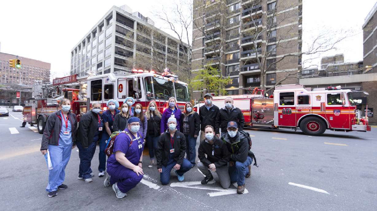 This undated photo shows Intermountain Healthcare workers posing in front of fire trucks in New York City during the early COVID-19 pandemic.