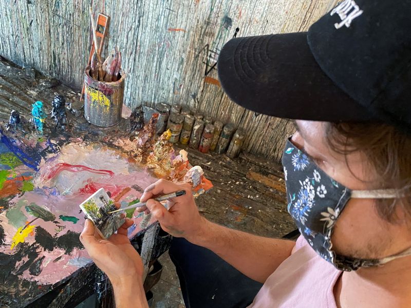 FILE PHOTO: Artist Steve Wasterval paints a miniature painting in his Greenpoint Brooklyn studio in New York City, New York, U.S., April 29, 2021. REUTERS/Roselle Chen