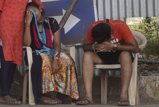 Relatives of a person who died of COVID-19 mourn outside a field hospital in Mumbai, India, Monday, May 3, 2021.