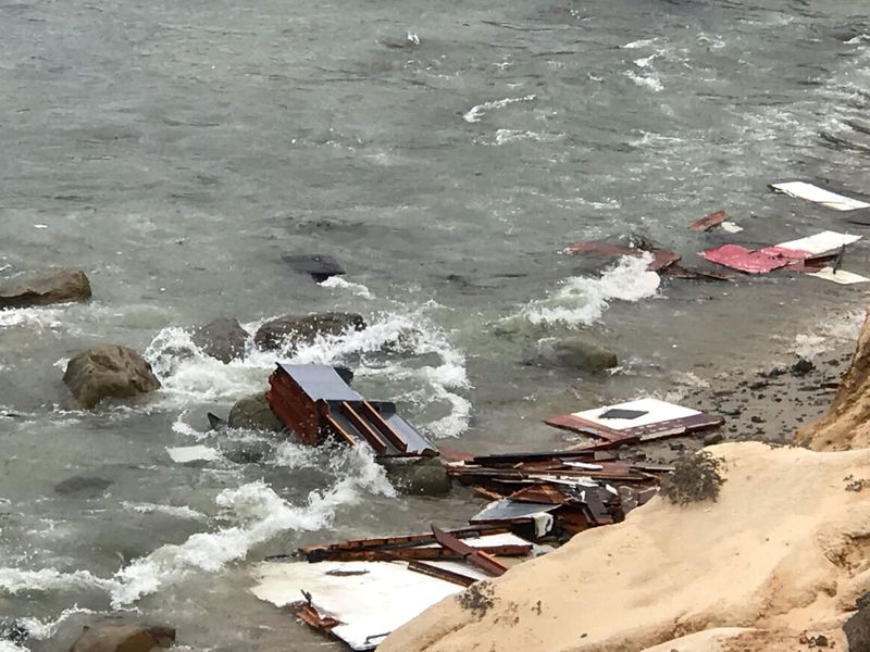 Debris lies in the water after a deadly boat incident, where a 40' cabin cruiser broke up along rocks at Point Loma, San Diego, California, U.S., May 2, 2021 in this image obtained from social media. San Diego Fire-Rescue Department via REUTERS