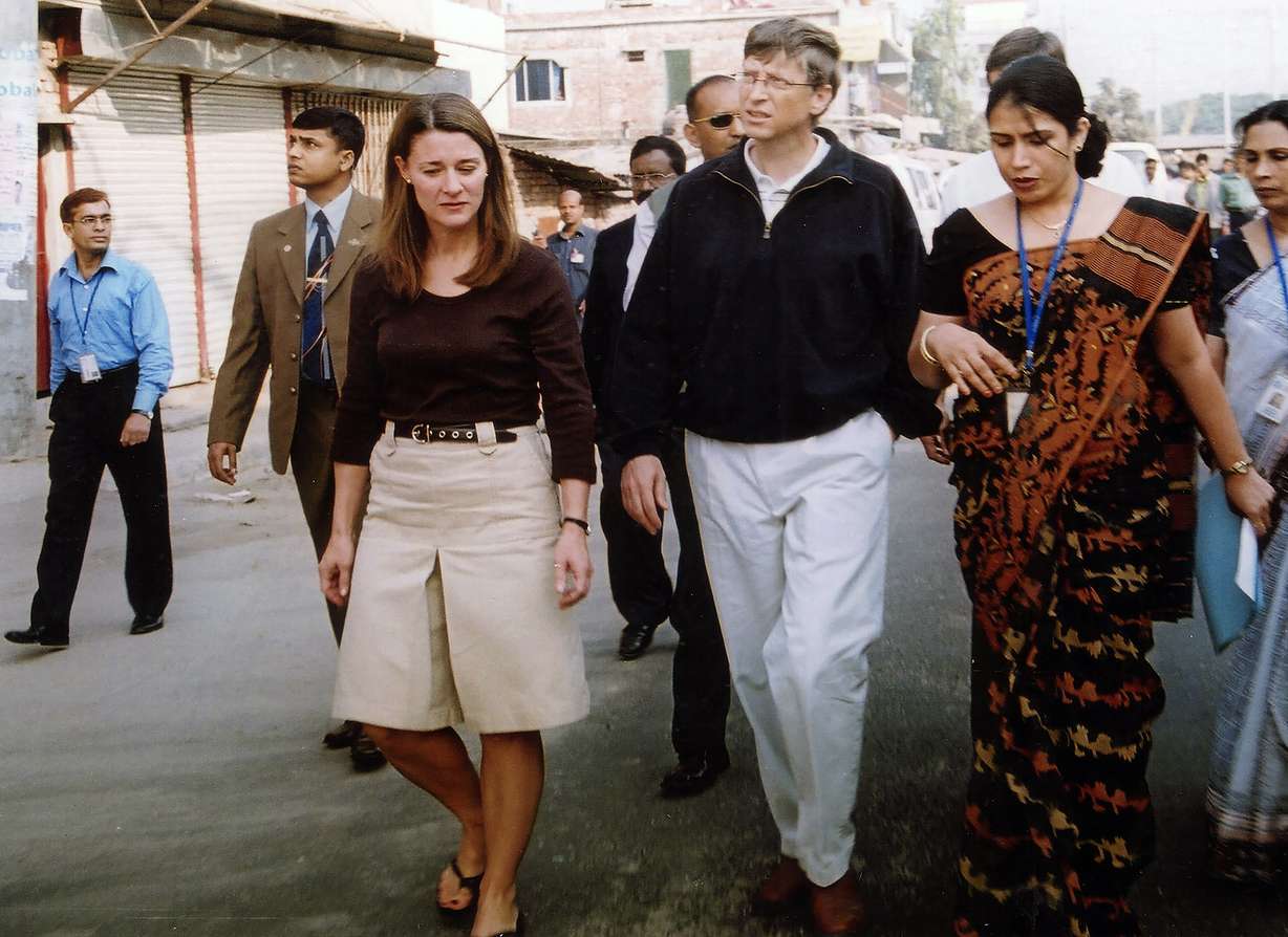 FILE - In this Dec. 5, 2005, file photo, Bill Gates, founder and chairman of Microsoft Corp., center, and his wife Melinda, left, walk on a street in Dhaka, Bangladesh. The couple announced Monday, May 3, 2021, that they are divorcing. The Microsoft co-founder and his wife, with whom he launched the world's largest charitable foundation, said they would continue to work together at The Bill & Melinda Gates Foundation.