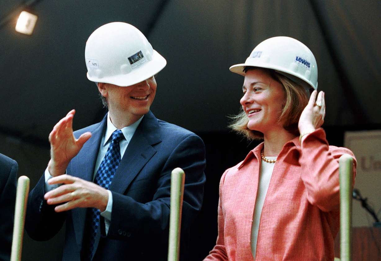 FILE - In this May 4, 2001, file photo, Microsoft Chairman Bill Gates contends with an ill-fitting hard hat while his wife, Melinda Gates, looks on in Seattle at the groundbreaking of the University of Washington's new law school facility, William H. Gates Hall. The couple announced Monday, May 3, 2021, that they are divorcing.