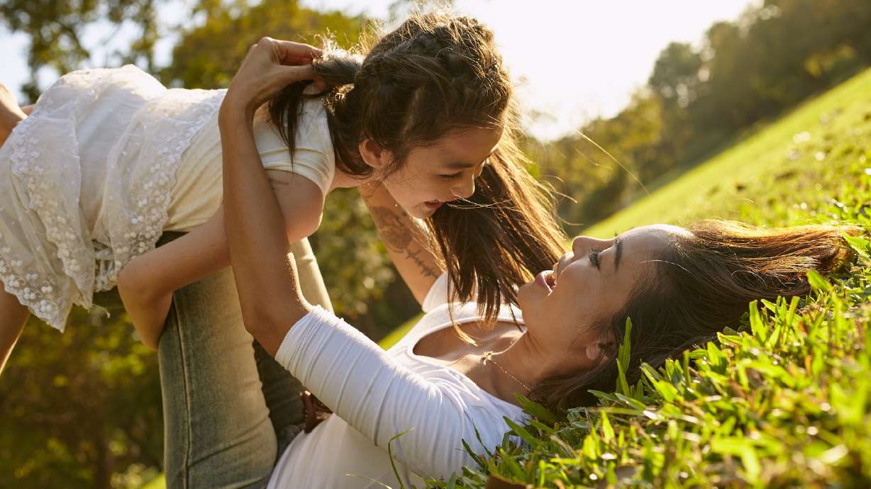 Lifestyle portrait mom and daughter in happines at the outside in the meadow