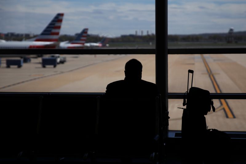 FILE PHOTO: A passenger waits for his flight at an empty terminal in Reagan International Airport as the spread of coronavirus disease (COVID-19) continues, in Washington, U.S., April 3, 2020. REUTERS/Carlos Barria