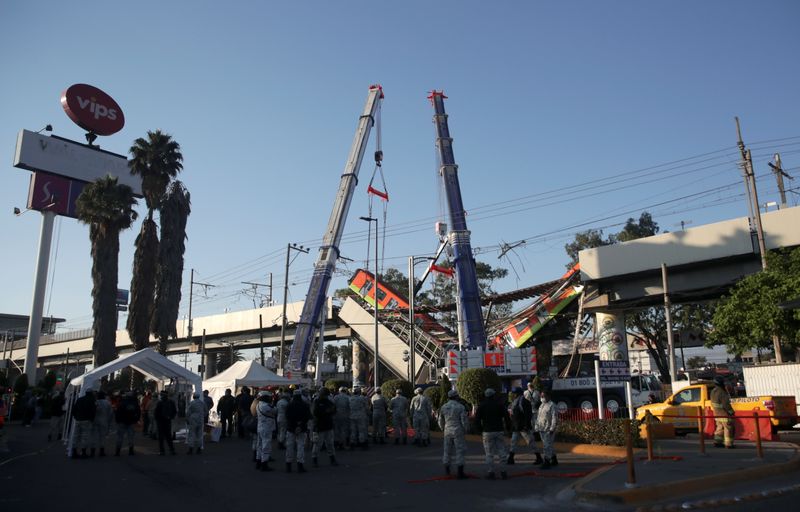 Rescuers work at a site where an overpass for a metro partially collapsed with train cars on it at Olivos station in Mexico City, Mexico, May 4, 2021.