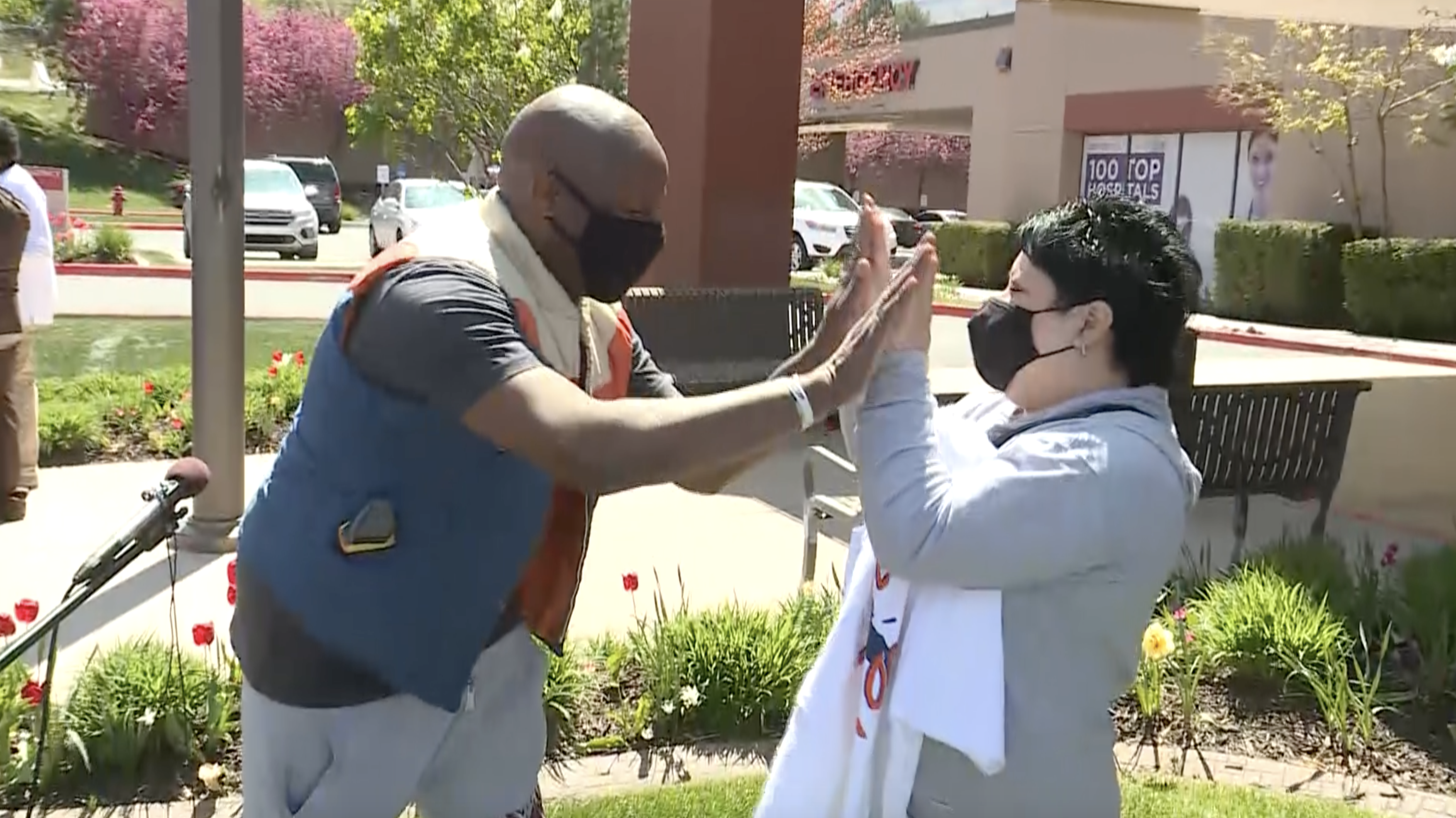 Singer Alex BoyƩ, left, and recovering COVID-19 victim Ana Lucio, right, share a high-five at MountainStar Lakeview Hospital in Bountiful on Tuesday, May 4, 2021. BoyƩ performed a curbside concert at the hospital to Lucio and front-line health workers early in the COVID-19 pandemic, and the two reunited Tuesday to mark the anniversary of BoyƩ's concert.