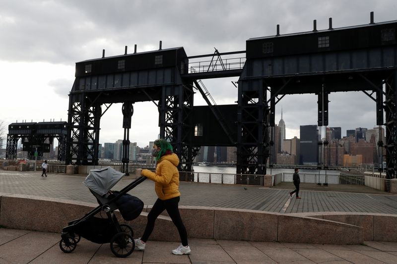 FILE PHOTO: A woman wearing a protective face mask pushes a baby stroller, amid the spread of the coronavirus disease (COVID-19), at Gentry Plaza State Park in the Queens borough of New York, U.S., March 1, 2021. REUTERS/Shannon Stapleton