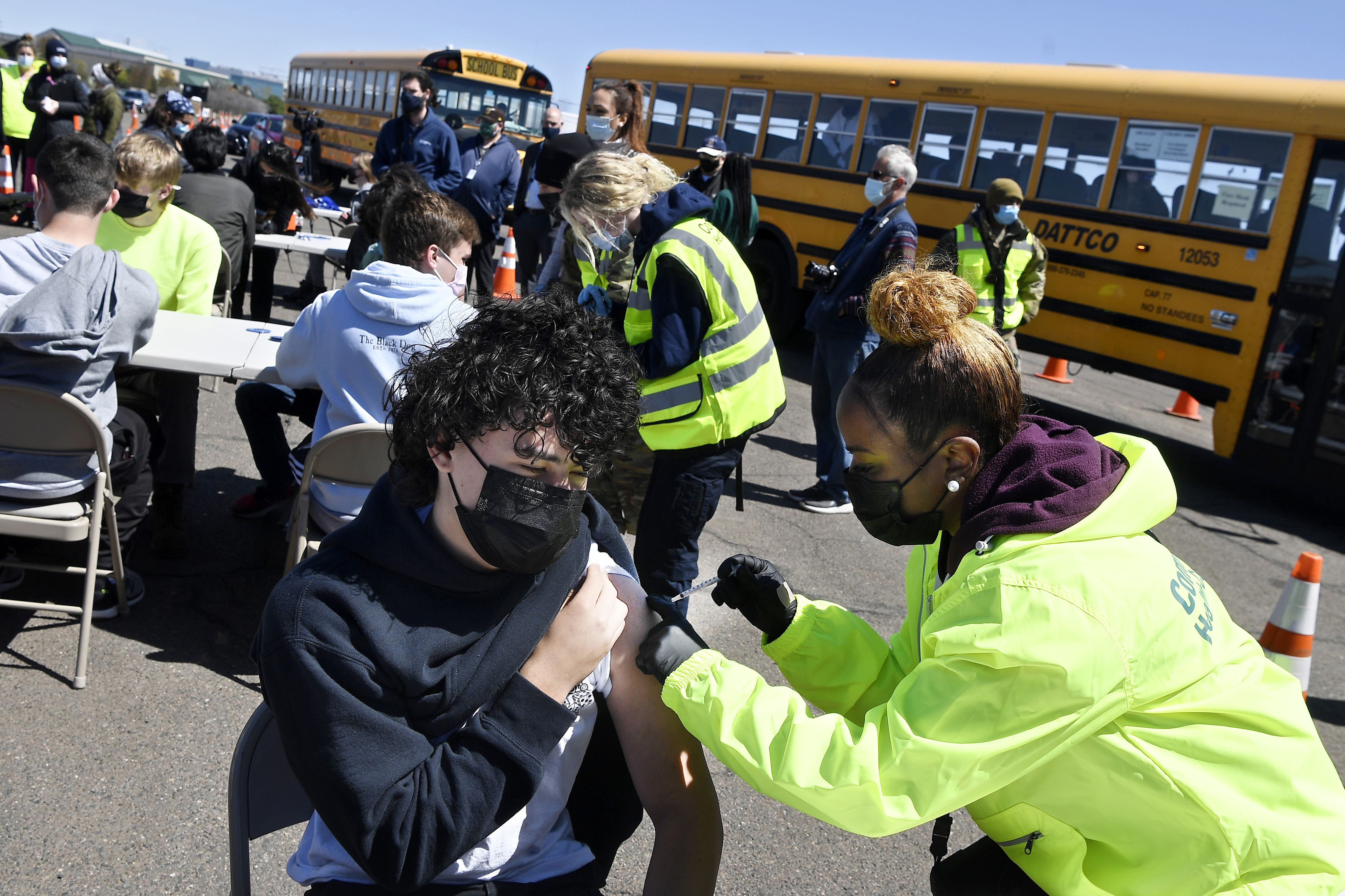 FILE - In this April 26, 2021, file photo, CREC Academy of Aerospace and Engineering sophomore Brian Acevedo, 16, receives a COVID-19 vaccine from nurse Myra Glass, of East Hartford, during a mass vaccination site at Pratt & Whitney Runway in East Hartford, Conn. Teams of experts are projecting COVID-19's toll on the U.S. will fall sharply by the end of July, according to research released by the government Wednesday, May 5. 