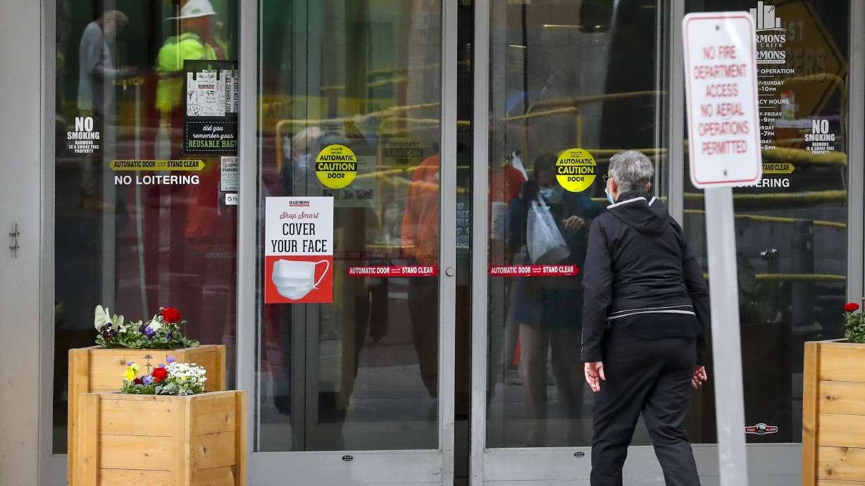 Signs remind customers to wear a mask while shopping at the Harmons grocery store in downtown Salt Lake City on Tuesday, April 6, 2021.