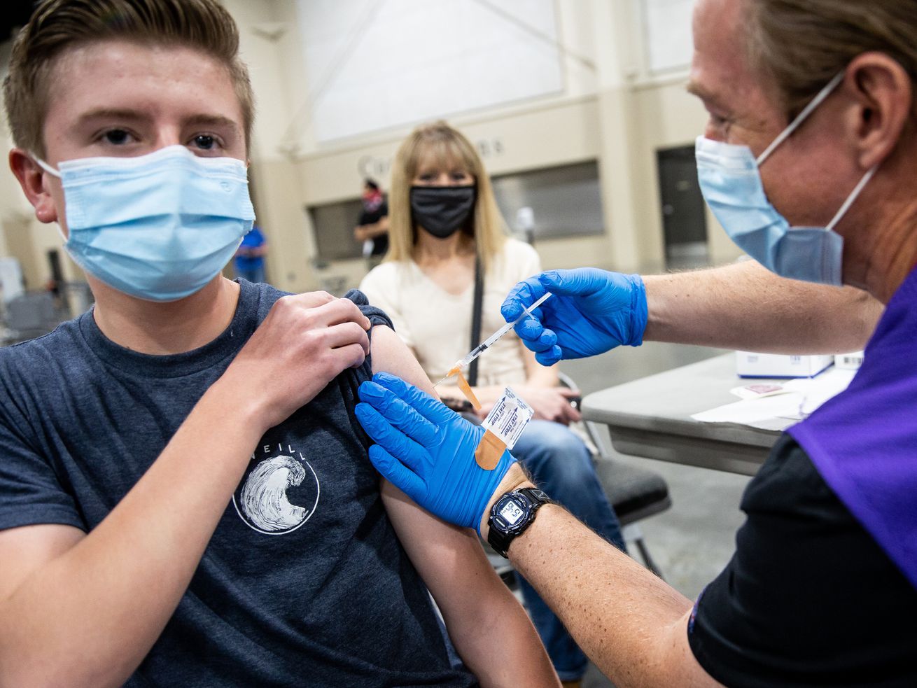 Jeffrey Gerhart, 16, gets his second dose of the Pfizer-BioNTech COVID-19 vaccine from advanced EMT Jonathan Pimble at the Mountain America Expo Center in Sandy on April 22. On Monday, Utah health officials reported 2,669 new COVID-19 cases since Friday, as well as 21 additional deaths. 