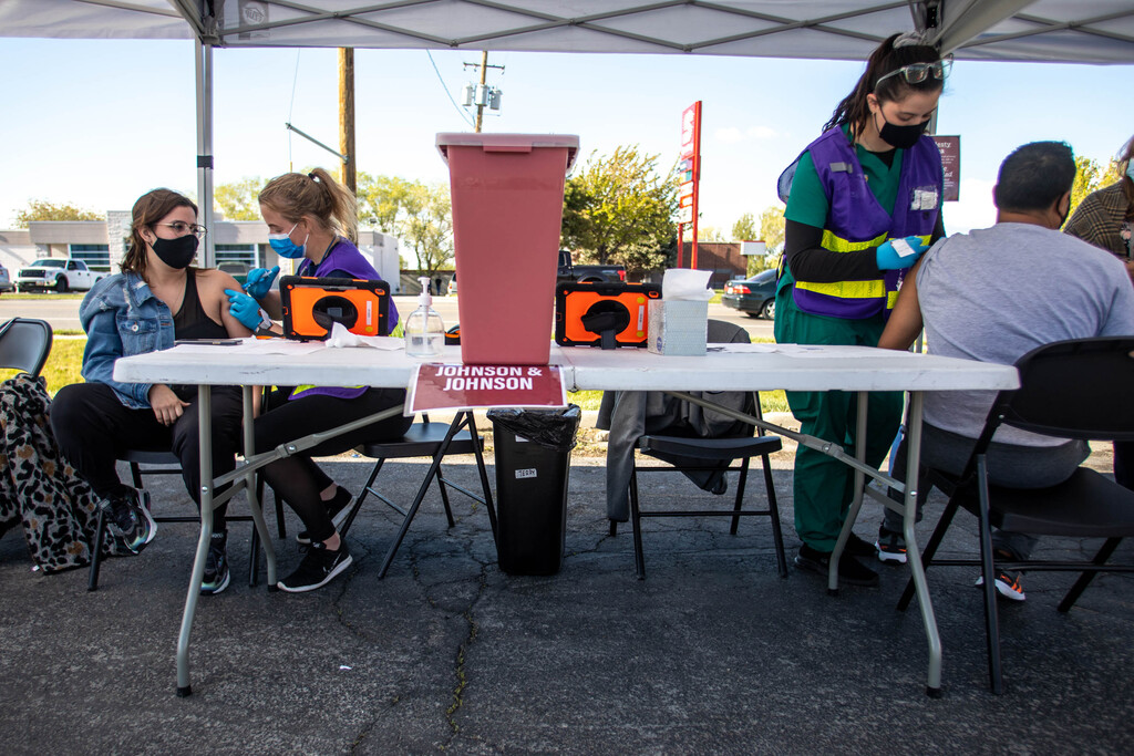 Estefania Matos, left, receives a COVID-19 vaccine from health care worker Danielle Davis as health care worker Nadia Swanson gives Danny Revete a COVID-19 vaccine at a pop-up vaccination event at Reams in Magna on Monday, May 3, 2021. The Salt Lake County Health Department is doing vaccination pop-up event with its mobile health center.