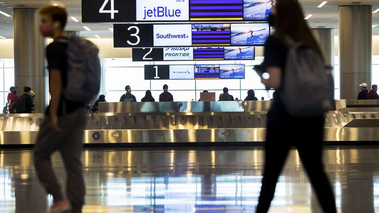 Travelers walk near the baggage claim at the Salt Lake
City International Airport on Friday, April 2, 2021.