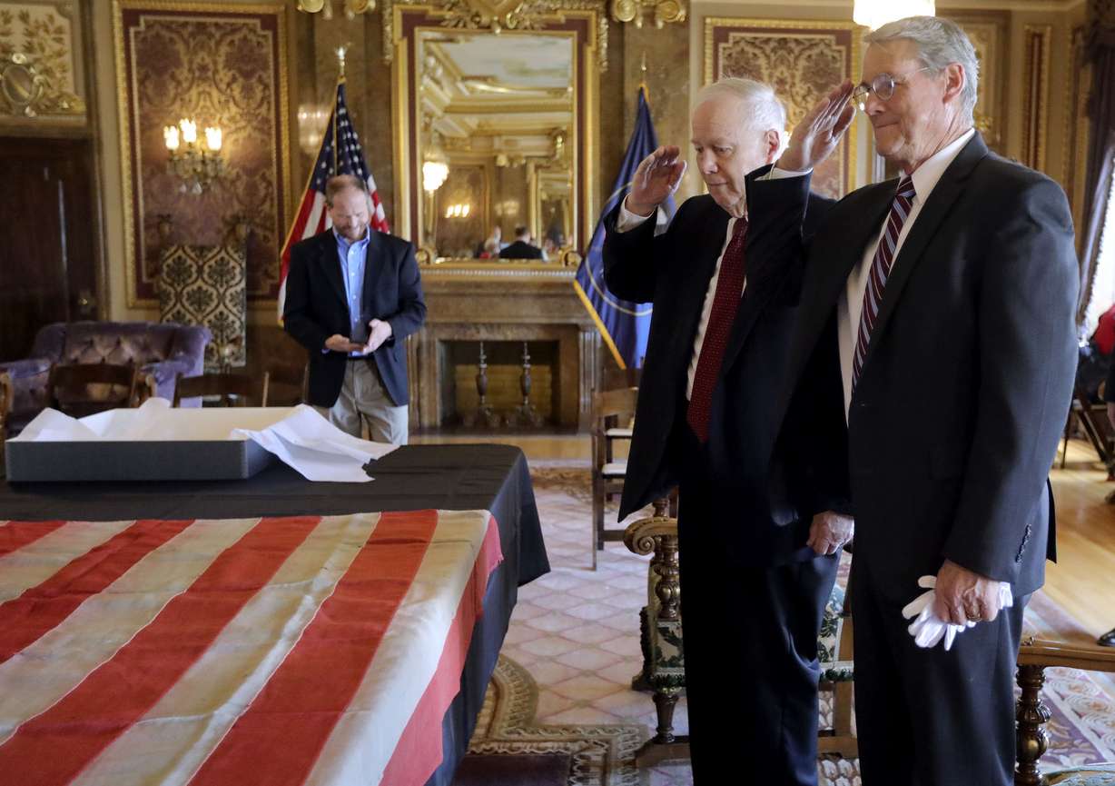 Serge Horton Benson, center, and Jan Benson, both military veterans, salute the 45-star flag that has been in their family after presenting it to the state at the Capitol in Salt Lake City on Tuesday, May 11, 2021. It is the original 45-star flag that flew over the U.S. Capitol when Utah became the 45th state in 1896. It will be displayed on the first floor of the Utah Capitol.