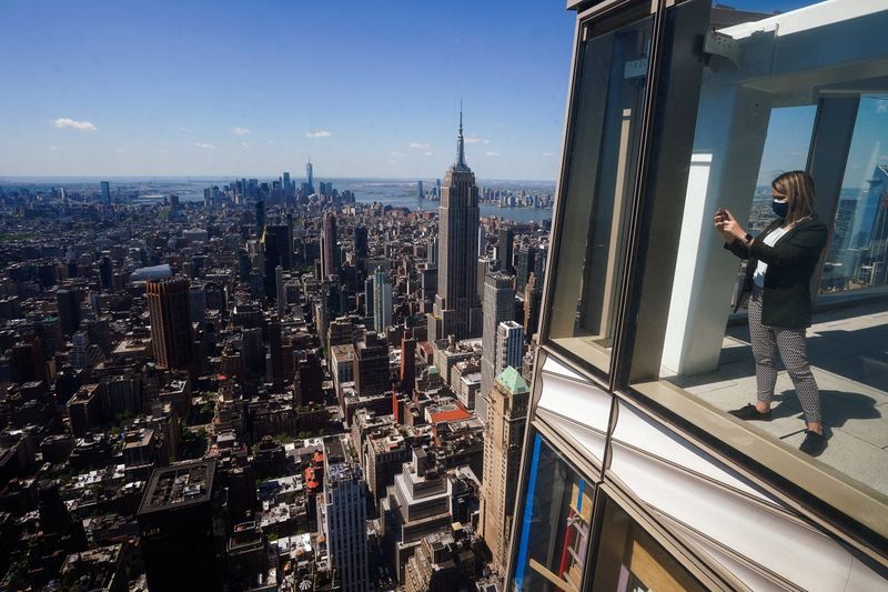 Alexis Tymorek takes pictures from the observation deck of the still under construction One Vanderbilt tower in the Manhattan borough of New York City, New York, U.S., May 11, 2021.  REUTERS/Carlo Allegri