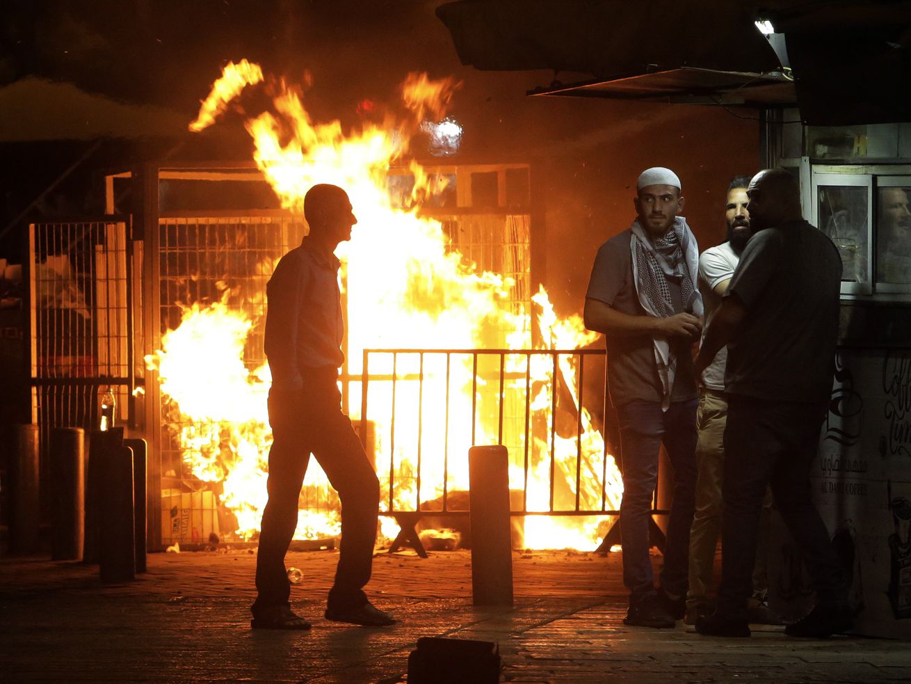 Palestinians gather near a fire burning next to the
Damascus Gate to the Old City of Jerusalem during clashes between
police and Palestinian protesters on Monday, May 10, 2021. Hamas
militants fired dozens of rockets into Israel on Monday, including
a barrage that set off air raid sirens as far away as Jerusalem,
after hundreds of Palestinians were hurt in clashes with Israeli
police at a flashpoint religious site in the contested holy city.
The rocket fire drew heavy Israeli retaliation in the Gaza Strip.