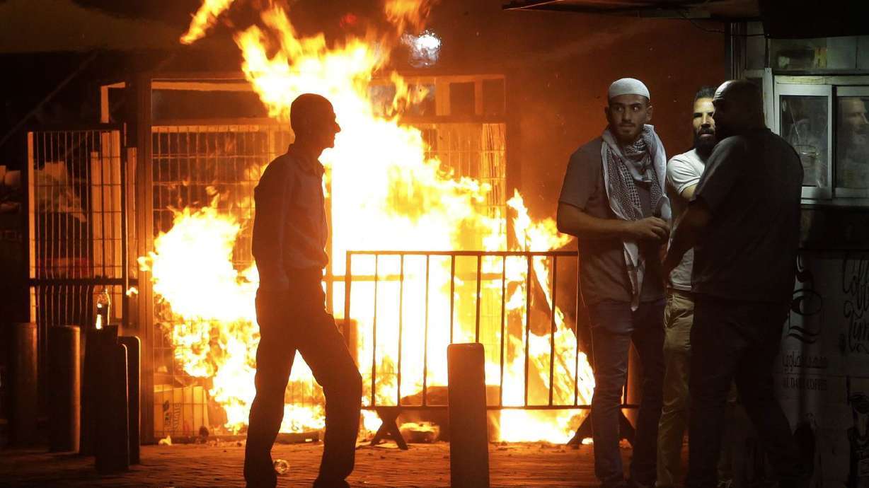 Palestinians gather near a fire burning next to the
Damascus Gate to the Old City of Jerusalem during clashes between
police and Palestinian protesters on Monday, May 10, 2021. Hamas
militants fired dozens of rockets into Israel on Monday, including
a barrage that set off air raid sirens as far away as Jerusalem,
after hundreds of Palestinians were hurt in clashes with Israeli
police at a flashpoint religious site in the contested holy city.
The rocket fire drew heavy Israeli retaliation in the Gaza Strip.