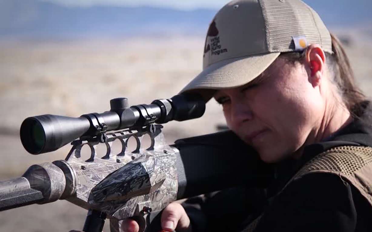 Volunteer Jessica Franzen prepares to fire a dart that delivers a shot of PZP, which makes a mare temporarily sterile.
