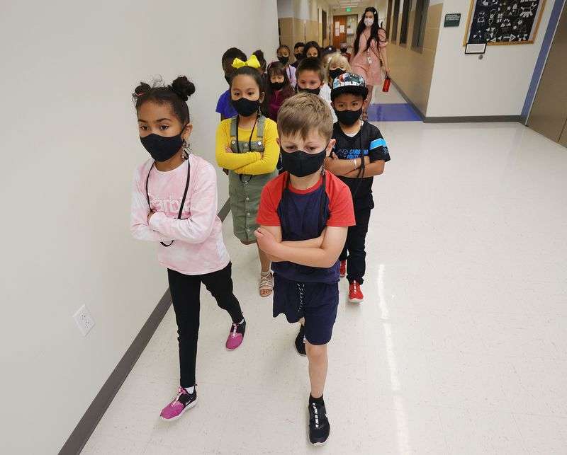 First graders Allison Mejia Medina, left, Tatum Ashy,
right and their classmates wear masks as they go to lunch at
Woodrow Wilson Elementary School in Salt Lake City on Wednesday,
May 12, 2021.