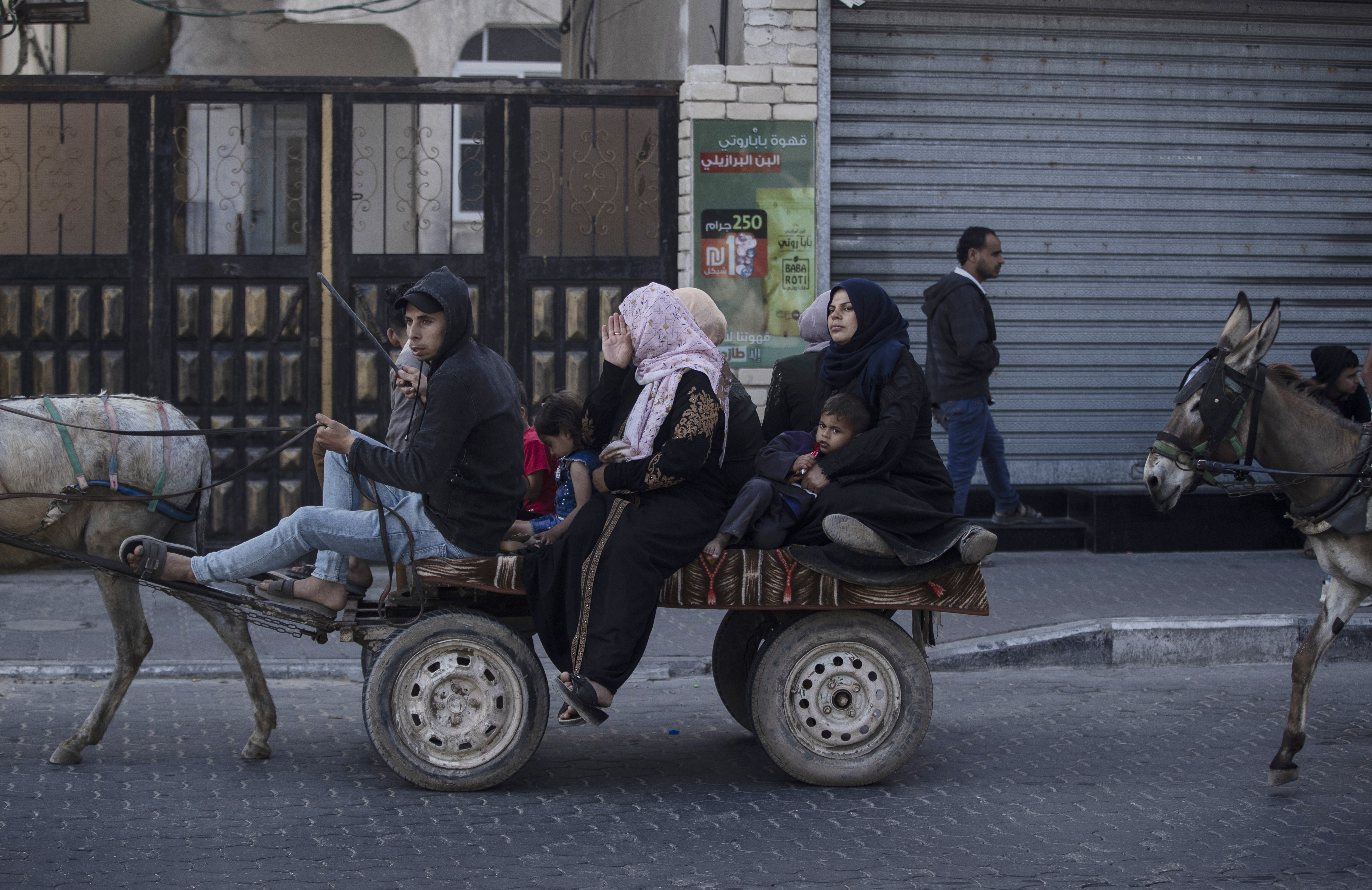Palestinians flee their homes after overnight Israeli heavy missile strikes on their neighborhoods in the outskirts of Gaza City, Friday, May 14, 2021.