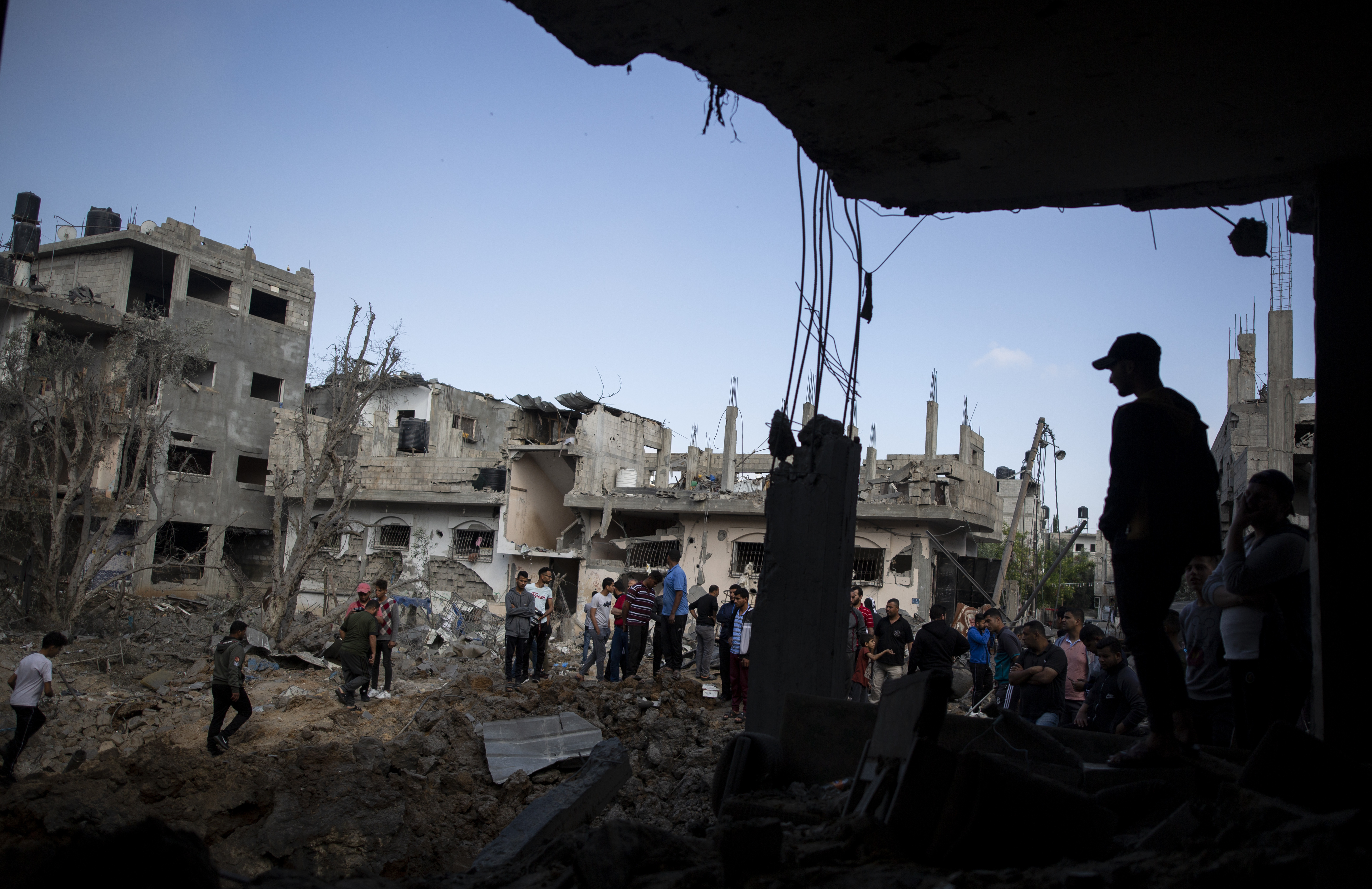 Palestinians inspect their destroyed houses following overnight Israeli airstrikes in town of Beit Hanoun, northern Gaza Strip, Friday, May 14, 2021.