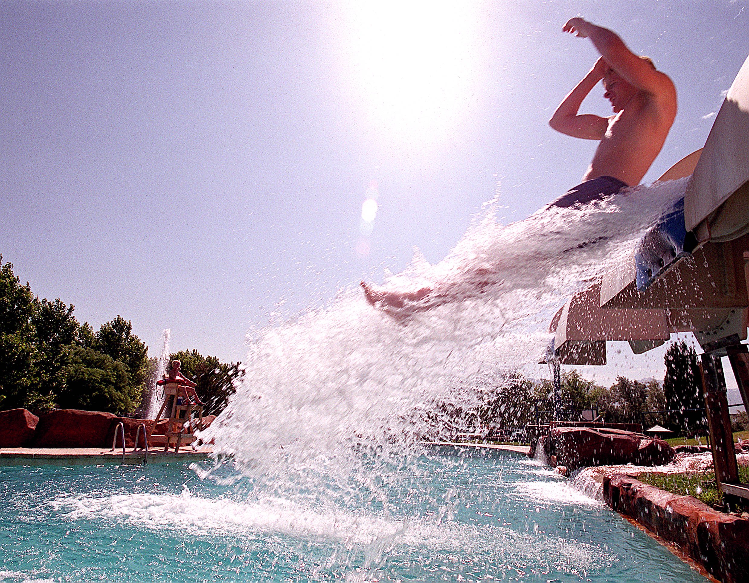 Chris Lambe shoots out over the pool as he enjoys the hot weather at Raging Waters, Friday June 22, 2001. Photo by Scott G. Winterton/Deseret News.