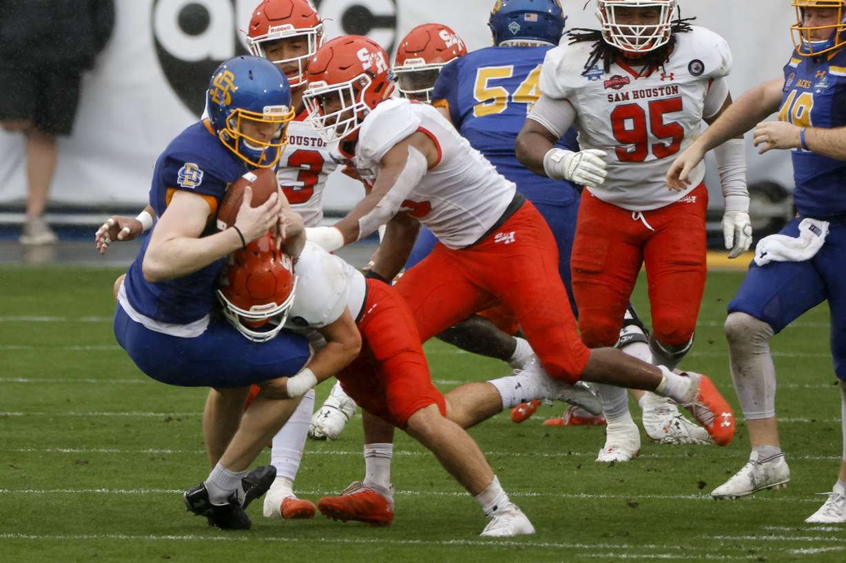 Sam Houston State defenders tackle South South Dakota State place kicker Cole Frahm, front left, after a fumble on a field goal-attempt during the first half of the NCAA college FCS Football Championship in Frisco, Texas, Sunday, May 16, 2021.