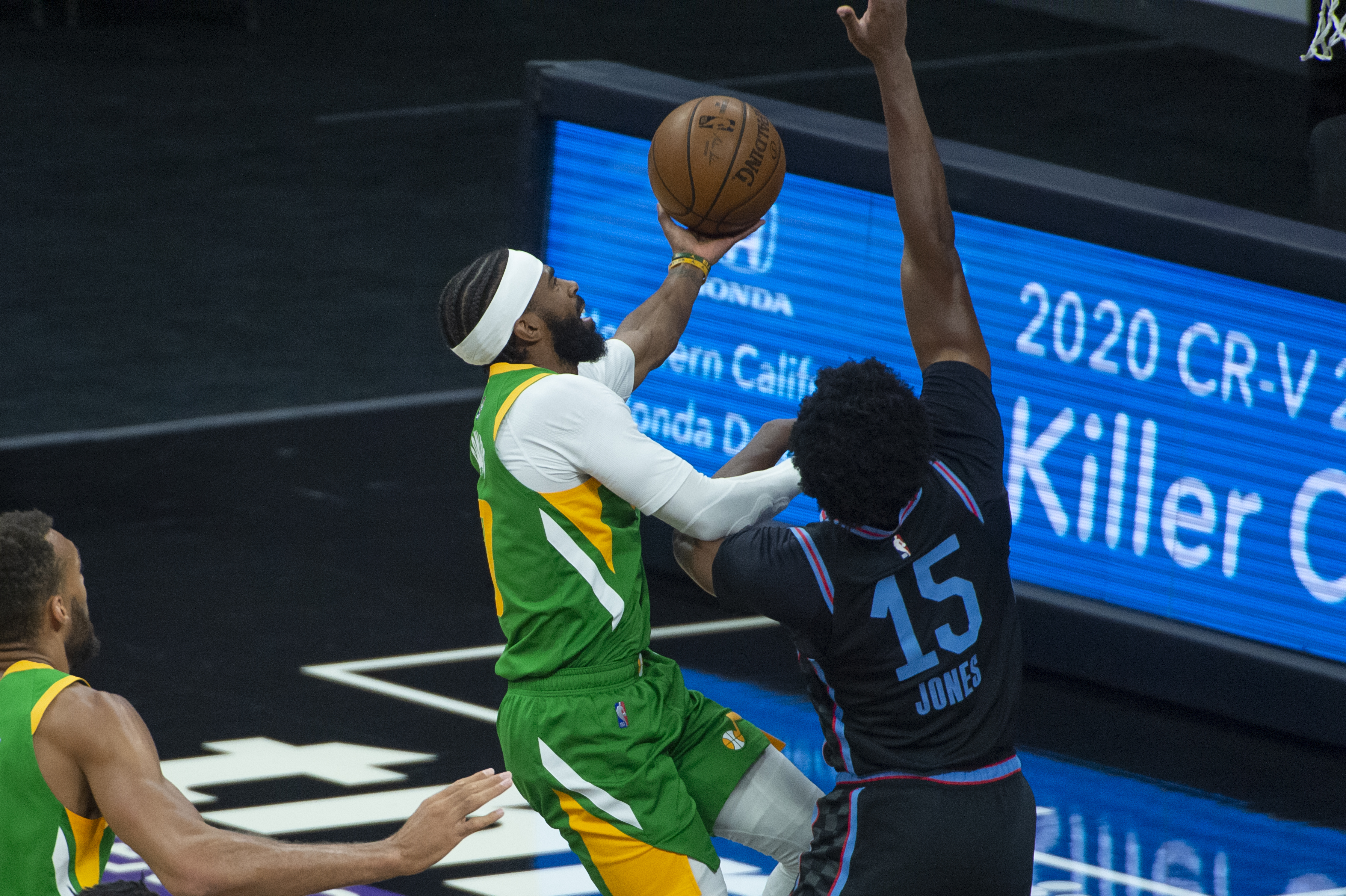 Utah Jazz guard Mike Conley, left, drives to the basket as Sacramento Kings center Damian Jones, right, defends during the first quarter of an NBA basketball game in Sacramento, Calif., Sunday, May 16, 2021.