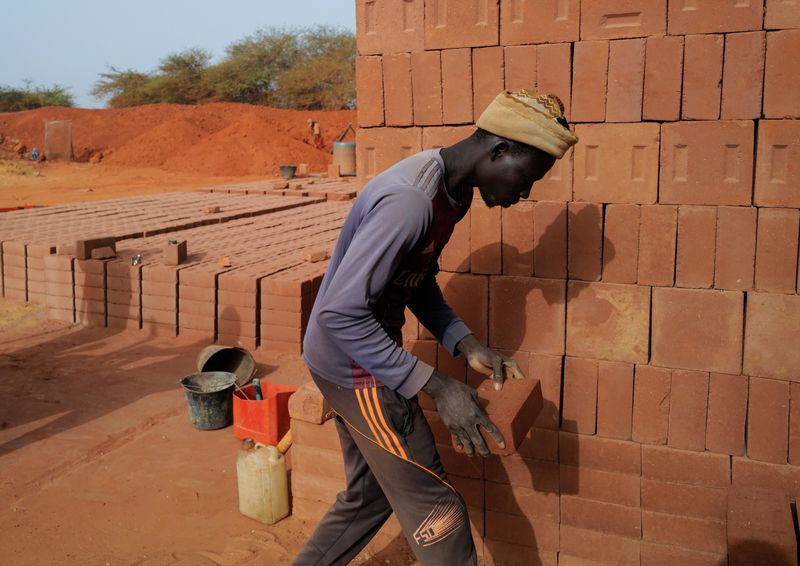 A worker carries a newly made brick at the Elementerre factory in Mbour, Senegal May 10, 2021. Picture taken May 10, 2021. REUTERS/Zohra Bensemra