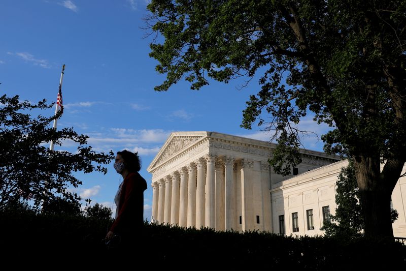 FILE PHOTO: A person in a mask walks past the United States Supreme Court Building in Washington, D.C., U.S., May 13, 2021. REUTERS/Andrew Kelly