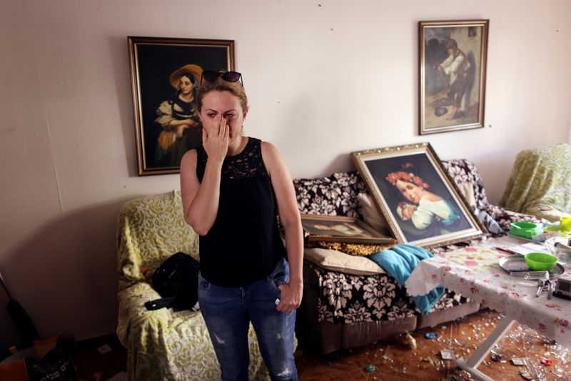 Sveta Shtilrman stands at her living room inside a damaged building following a rocket attack from Gaza, in Ashdod, Israel May 17, 2021.