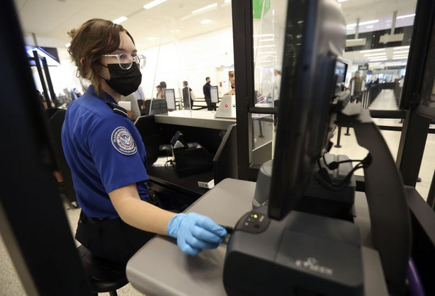 Staci Merten, a transportation security officer wit the Transportation Security Administration, checks a passenger’s
identification at the TSA security checkpoint at Salt Lake City
International Airport in Salt Lake City on Tuesday, May 18, 2021. Air travel is expected to increase this summer.