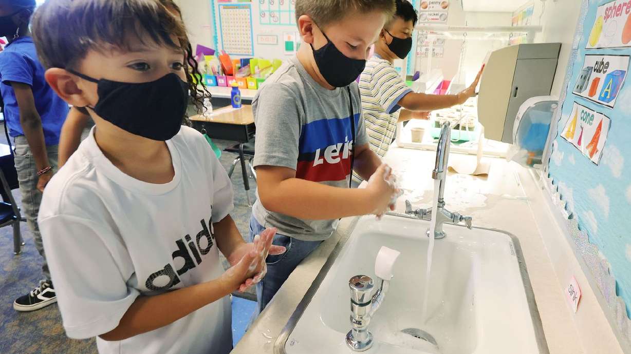 First graders Gilbert Grant and Monty Fox wear masks as they wash their hands before lunch at Woodrow Wilson Elementary School in Salt Lake City on Wednesday, May 12, 2021. The Utah Legislature is set to tackle whether to ban face mask requirements in schools in a special session on Wednesday, May 19, 2021.