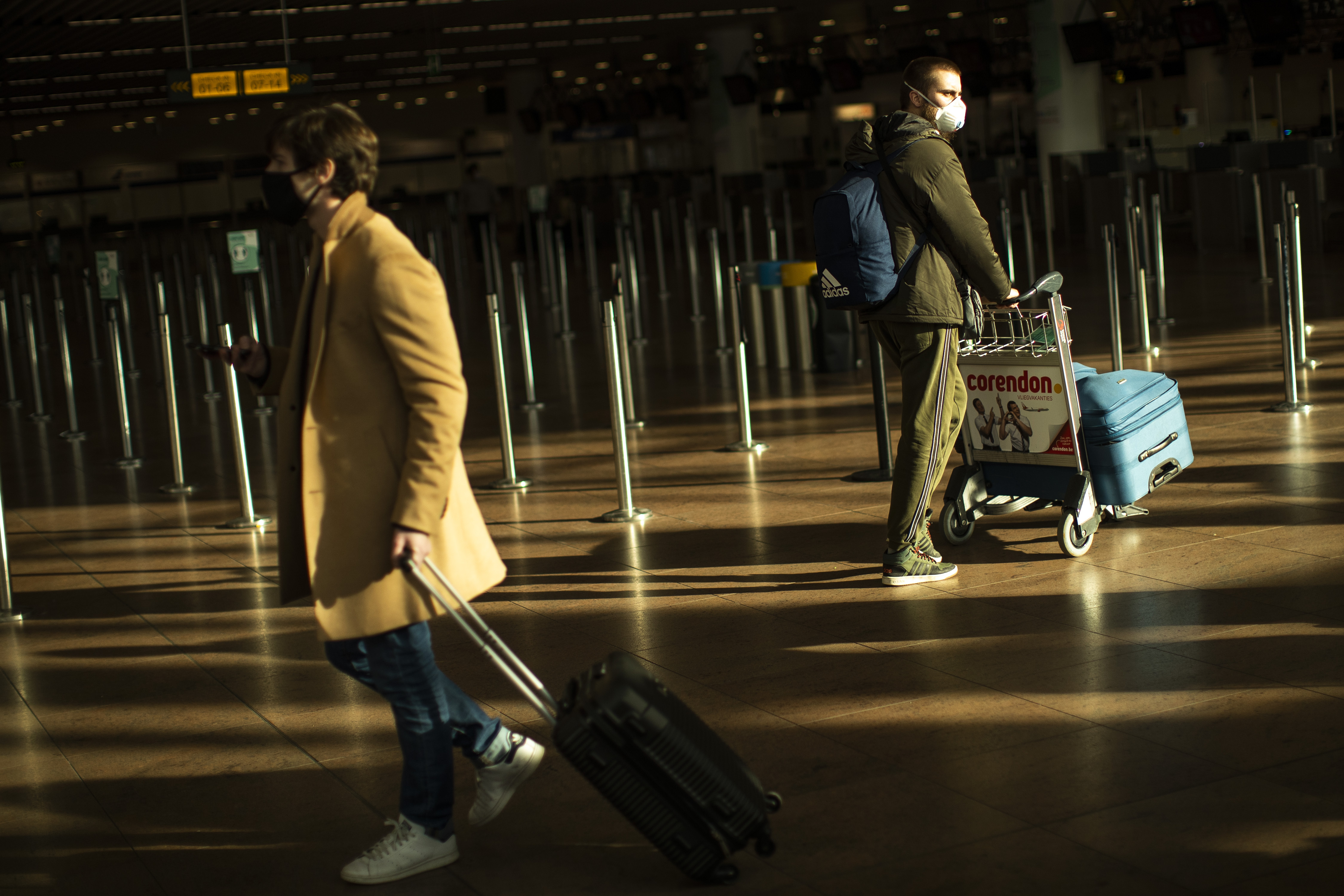 FILE - In this Jan. 22, 2021, file photo, travellers, wearing face masks to prevent the spread of the coronavirus COVID-19, walk along the departure hall of the Zaventem international airport in Brussels. The European Commission proposed Thursday April 29, 2021, issuing “Digital Green Certificates” to EU residents to facilitate travel across the 27-nation bloc by the summer 2021, as long as they have been vaccinated, tested negative for COVID-19 or recovered from the disease. (AP Photo/Francisco Seco, File)