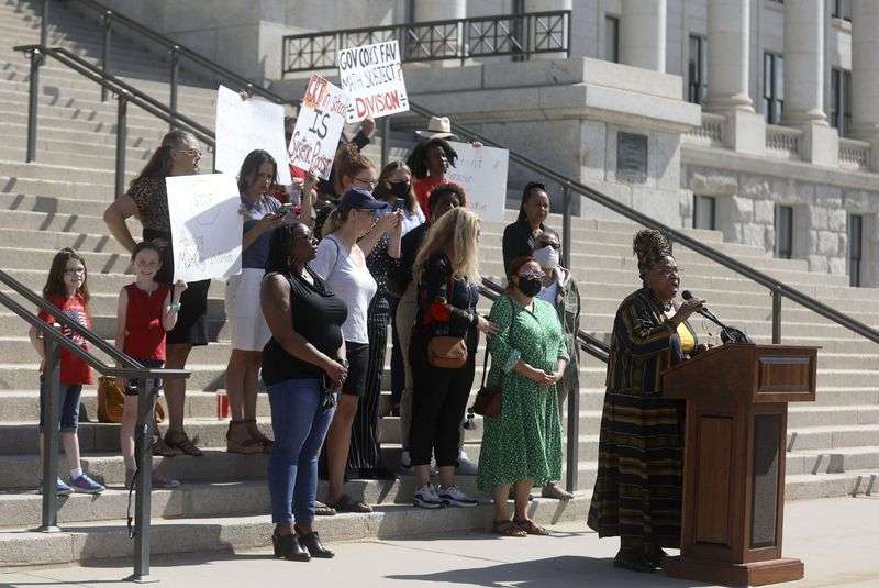 Betty Sawyer joins educators and community activists in protesting Utah lawmakers’ plans to pass resolutions encouraging a ban of critical race theory concepts outside of the Capitol in Salt Lake City on Wednesday, May 19, 2021, as counterprotesters stand behind her.