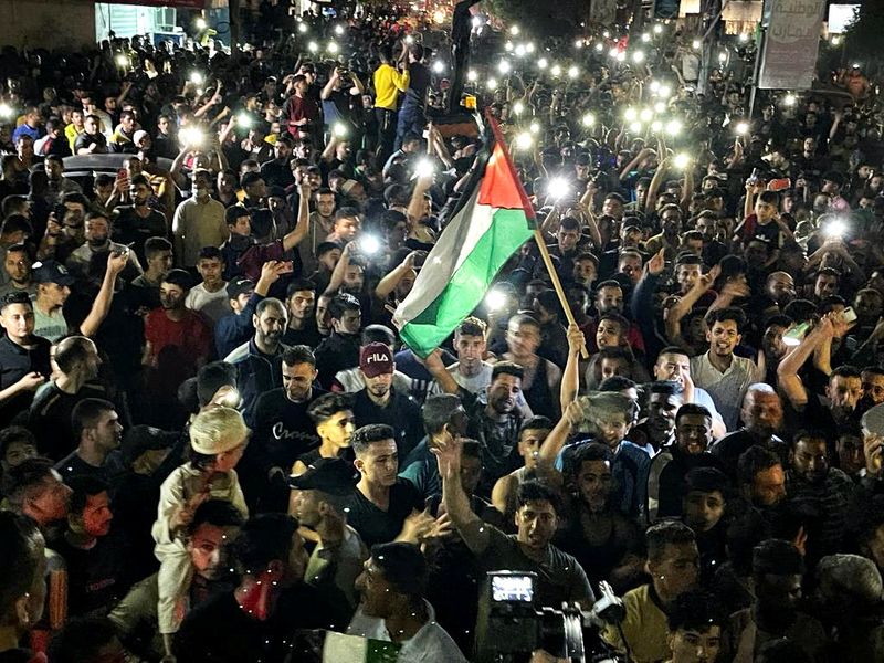 Palestinians celebrate in the streets following a ceasefire, in the southern Gaza Strip May 21, 2021.