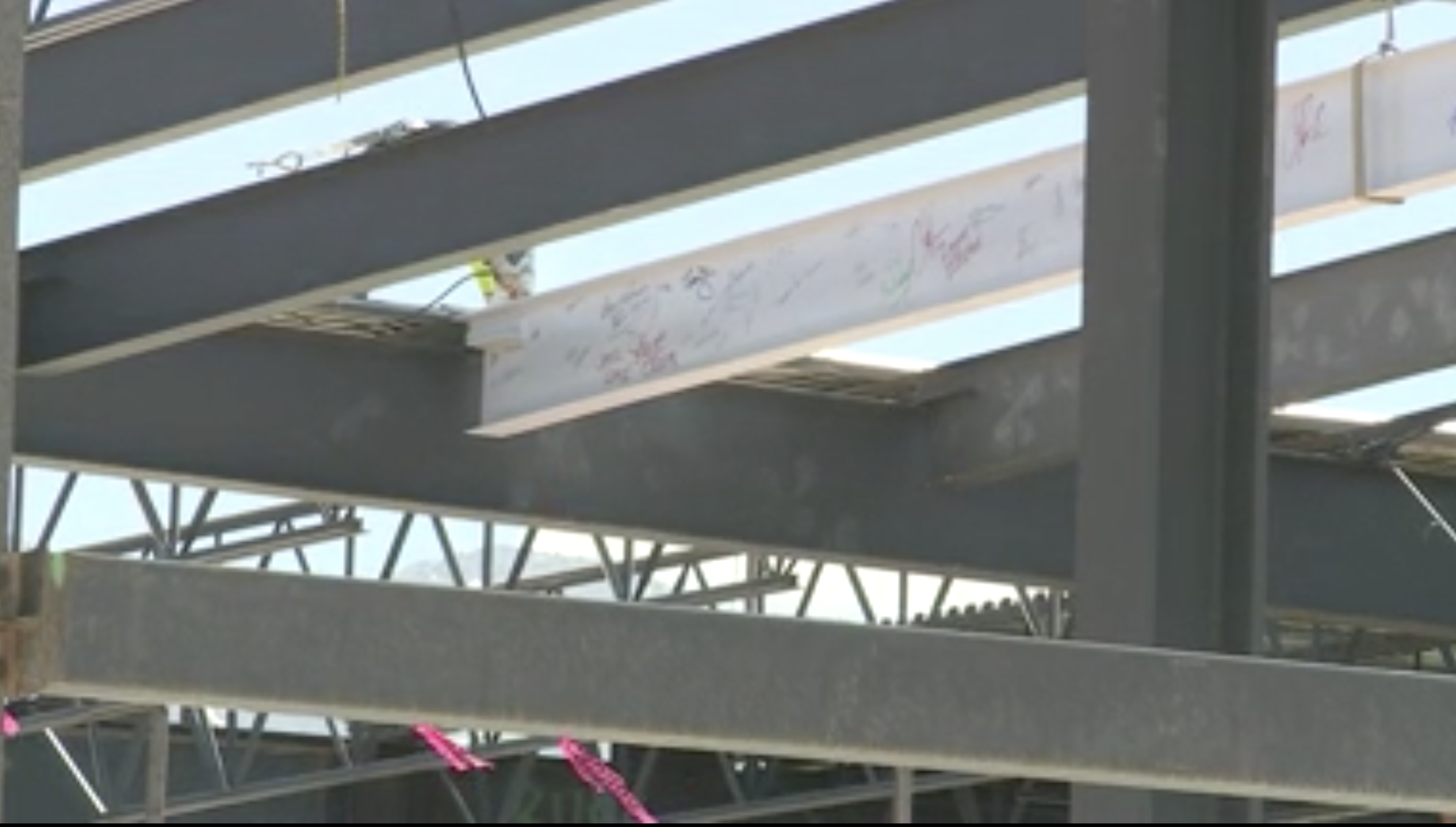 Construction crews lock into place a beam containing signatures of people who helped make the Provo Airport expansion happen during a ceremony on Thursday, May 20, 2021. The airport is expected to open in June 2022.