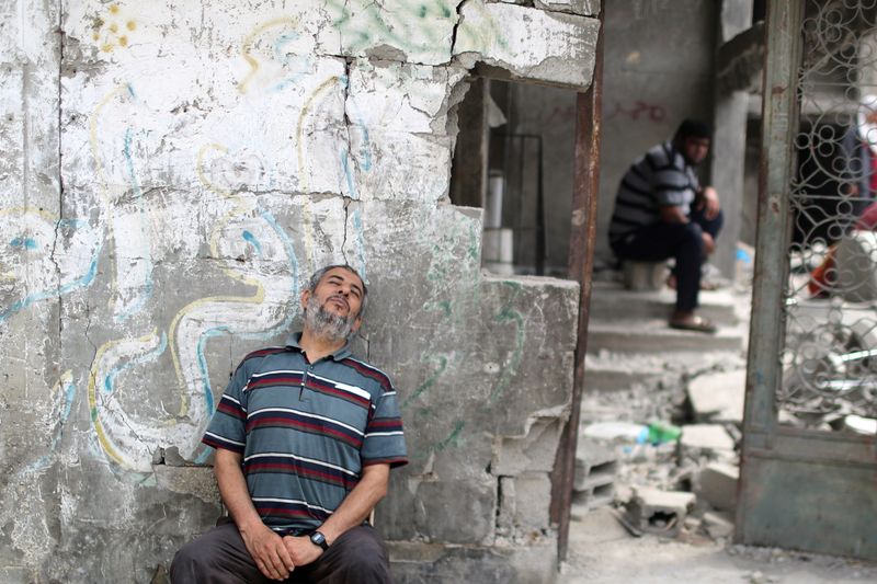 A Palestinian man rests after returning to his damaged house following Israel- Hamas truce, in Beit Hanoun in the northern Gaza Strip, May 21, 2021. REUTERS/Mohammed Salem