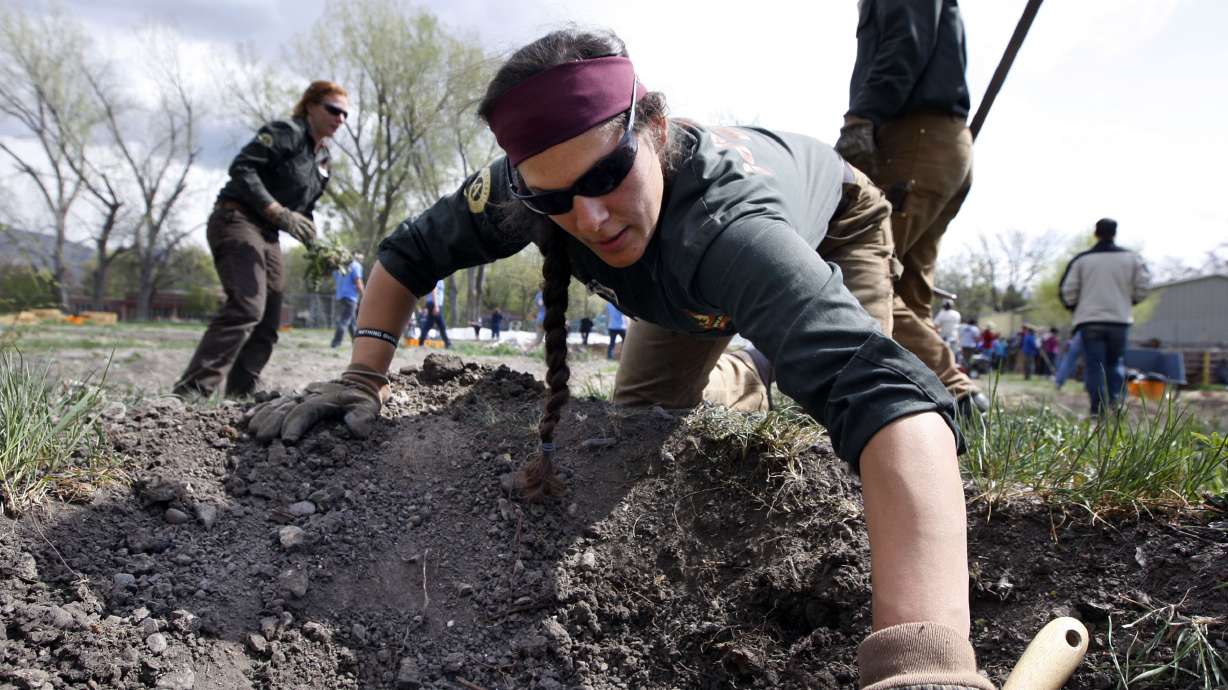 Ashley Cimmino, with Utah Conservation Corps, participates in a Real Food Rising service event in Salt Lake City Tuesday, April 7, 2015.