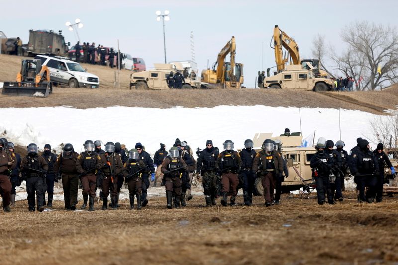 FILE PHOTO: Law enforcement officers advance into the main opposition camp against the Dakota Access oil pipeline near Cannon Ball, North Dakota, U.S., February 23, 2017. REUTERS/Terray Sylvester/File Photo