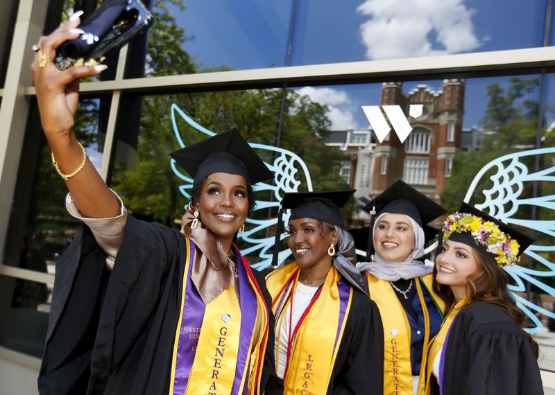 Sisters Asma and Anisa Dahir, Shubaira Aminzada and
Salma Guerrero, public health students, take photos before their
graduation ceremony at Westminster College in Salt Lake City on
Friday, May 7, 2021.