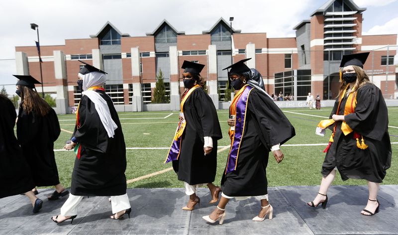 The Dahir sisters, Asma and Anisa, walk with other
public health students to their graduation ceremony at Westminster
College in Salt Lake City on Friday, May 7, 2021.