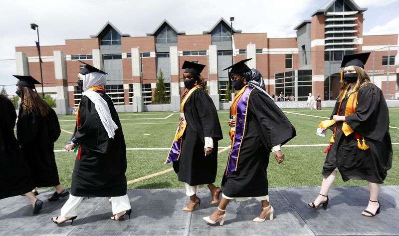 The Dahir sisters, Asma and Anisa, walk with other
public health students to their graduation ceremony at Westminster
College in Salt Lake City on Friday, May 7, 2021.