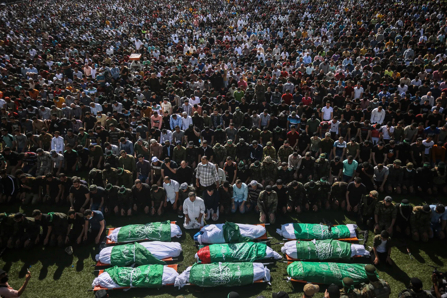 Palestinians pray by the bodies of members of the Izzedine al-Qassam Brigades, the military wing of Hamas movement, who died in Israeli bombardment of a tunnel, during their funeral in Khan Younis, southern Gaza Strip, Friday, May 21, 2021. A cease-fire took effect early Friday after 11 days of heavy fighting between Israel and Gaza’s militant Hamas rulers that was ignited by protests and clashes in Jerusalem.